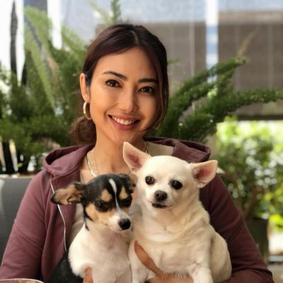 Chasty Ballesteros posing for a photo shoot while holding her both dogs in her hand.